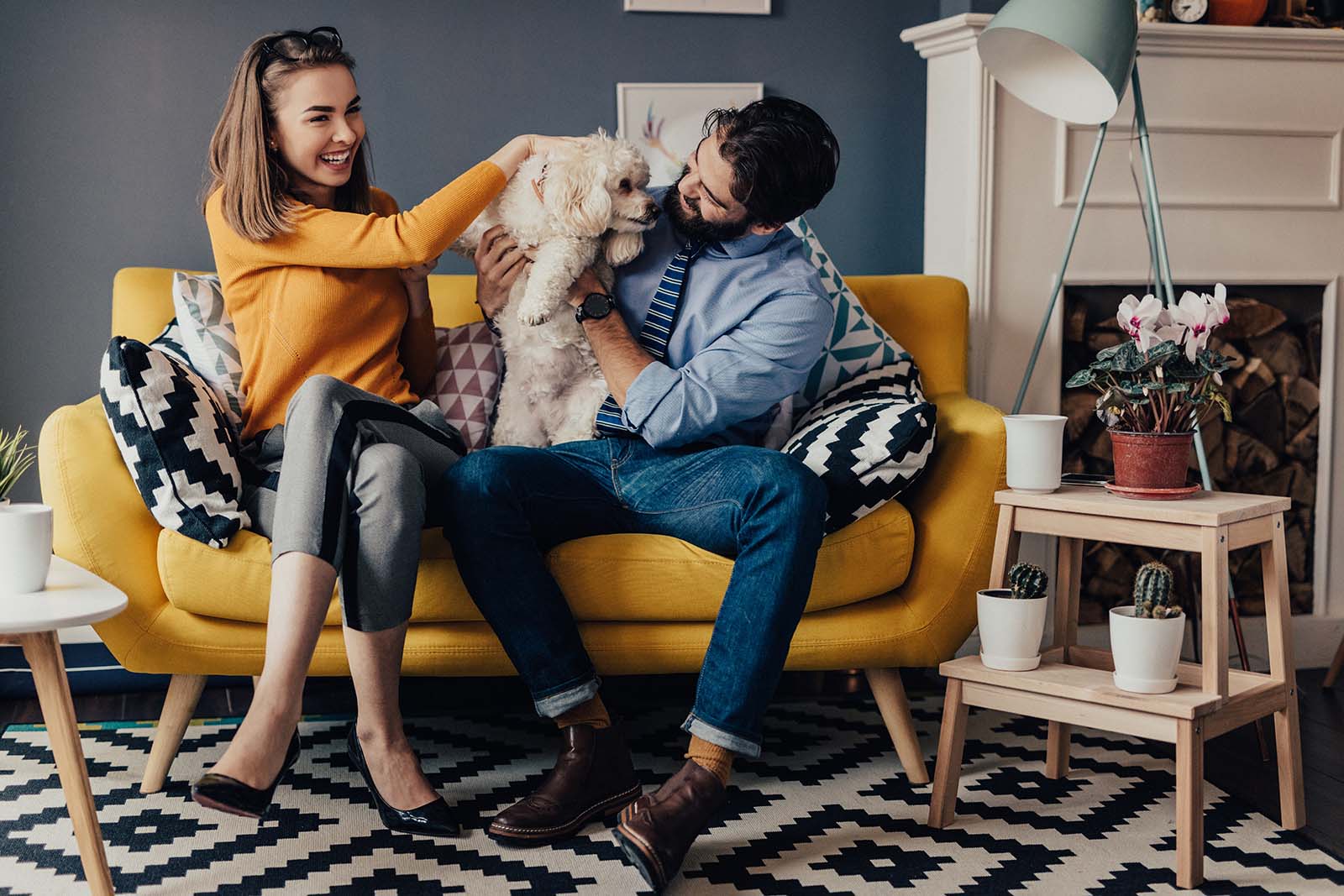 Young couple on loveseat with dog