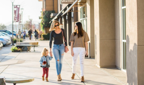two women and a young girl walking down the sidewalk